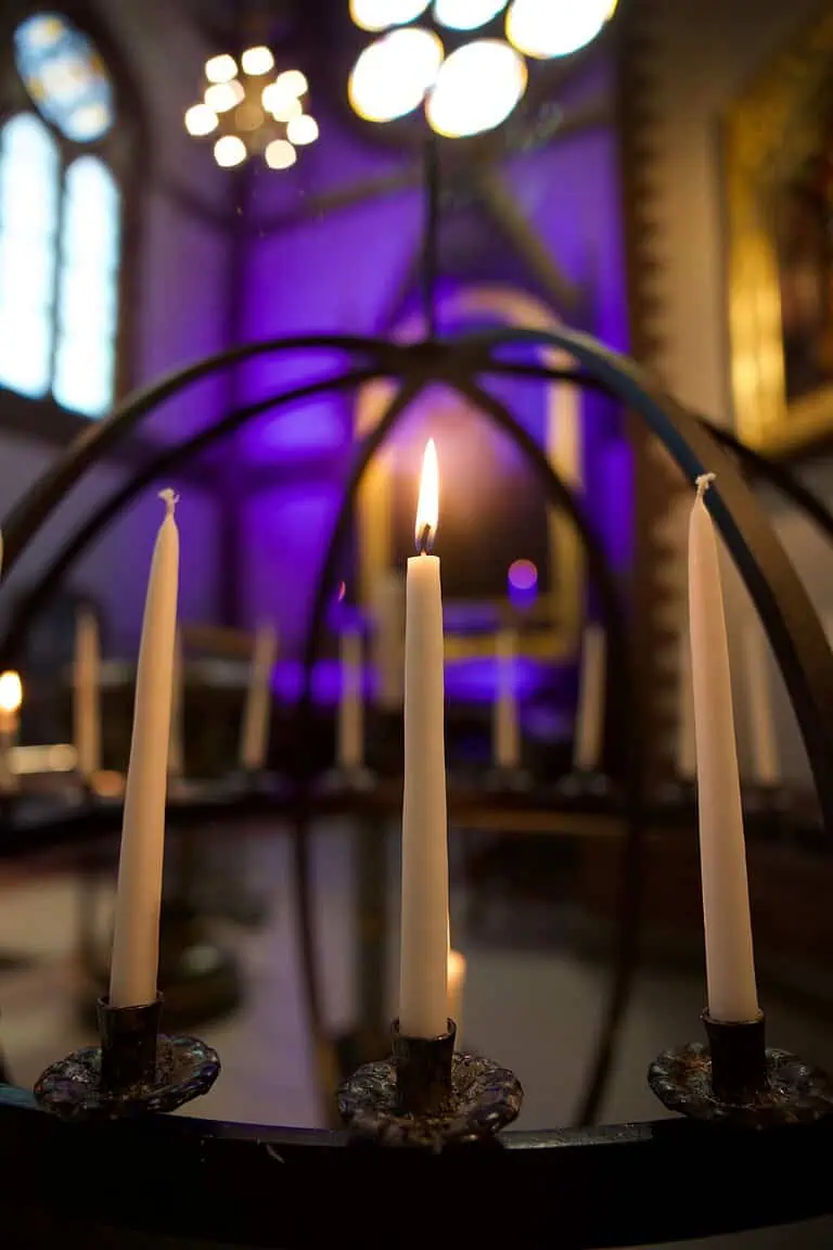 Lys tent i lysglobe i en kirke belyst i lilla